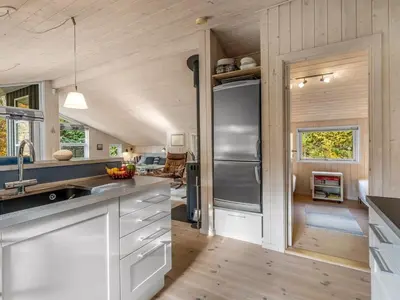 a kitchen with white cabinets and a stainless steel refrigerator at Holiday Home Peder - 4km from the sea by Interhome in Fjerritslev