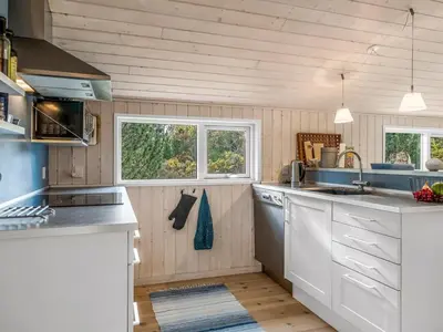 a kitchen with white appliances and two windows at Holiday Home Peder - 4km from the sea by Interhome in Fjerritslev