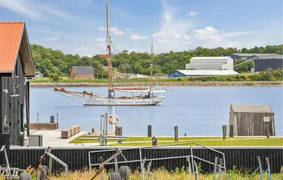a boat is docked on the water next to a building at Awesome Home In Thisted With House Sea View in Thisted