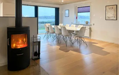 a living room with a fireplace and a table and chairs at Awesome Home In Thisted With House Sea View in Thisted