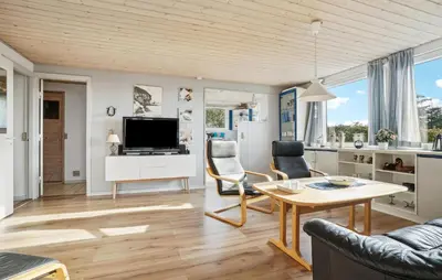 a living room with a table and chairs and a tv at Amazing Home In Snedsted With Wifi in Snedsted