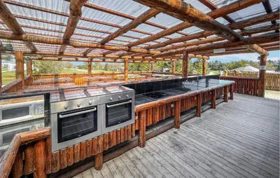 a large outdoor kitchen with a grill on a deck at Gorgeous Home In Hanstholm With Swimming Pool in Hanstholm