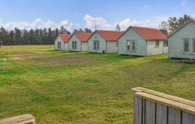 a row of houses with red roofs in a field at Beautiful Home In Hanstholm With House A Panoramic View in Hanstholm