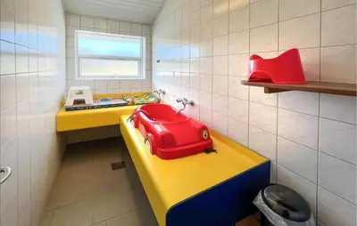 a small bathroom with a red bag on a yellow counter at Lovely Home In Hanstholm With Private Swimming Pool, Can Be Inside Or Outside in Hanstholm