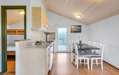 a kitchen and dining room with a table and chairs at Lovely Home In Hanstholm With Private Swimming Pool, Can Be Inside Or Outside in Hanstholm