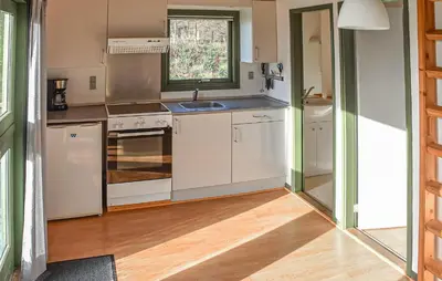 a kitchen with white appliances and a wooden floor at Stunning Home In Hanstholm With Outdoor Swimming Pool in Hanstholm