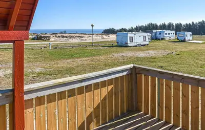 a wooden fence next to a yard with two rvs at Gorgeous Home In Hanstholm With Outdoor Swimming Pool in Hanstholm