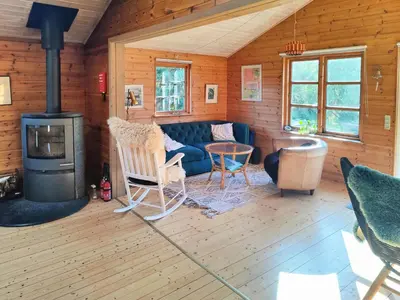a living room with a couch and a stove at Cozy Cottage Close To Thy National Park in Thisted