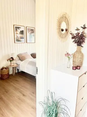 a bedroom with a bed and a mirror on the wall at Summer House Surrounded By Reeds Near Limfjorden in Lemvig