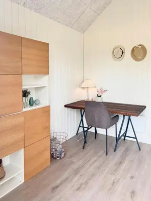 a desk in a room with a chair and a lamp at Summer House Surrounded By Reeds Near Limfjorden in Lemvig