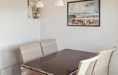 a dining room with a table and two chairs at Beautiful Home In Hanstholm With Swimming Pool in Hanstholm