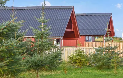 a red house with a fence and trees at 1 Bedroom Cozy Home In Hanstholm in Hanstholm