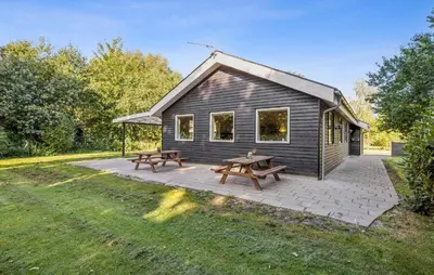 a house with a picnic table and two benches at Gorgeous Home In Farsø With Wifi in Farsø