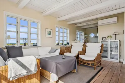 a living room with a couch and chairs and windows at BL1146-Saltum-Kalundborgvej-25 in Saltum