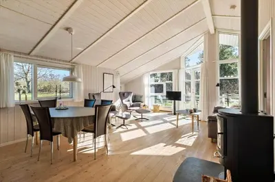 a dining room and living room with a table and chairs at JB368-Fjerritslev-Ahornvej-38