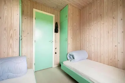 a room with two beds and a green wall at LK2201-Lokken-Kristavej-45 in Grønhøj