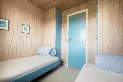 a small room with a bed and a door at LK2201-Lokken-Kristavej-45 in Grønhøj