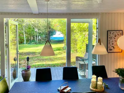 a dining room with a table and a large window at Nature Retreat With Fjord Views Near Spøttrup in Spottrup