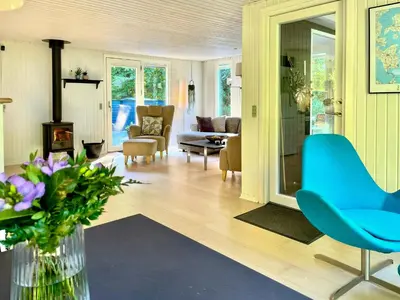 a living room with a blue chair and a couch at Nature Retreat With Fjord Views Near Spøttrup in Spottrup
