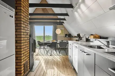 a kitchen with white cabinets and a dining room at 534-Lemvig-Lokkevej-13 in Lemvig