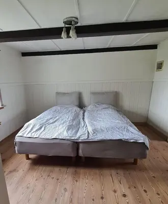 a bed in a room with a wooden floor at Horse Estate Farm Stay - Beautiful Surroundings in Bøvlingbjerg