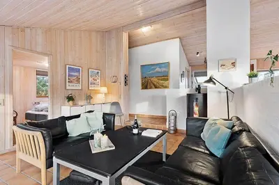 a living room with a leather couch and a table at BL1144-Blokhus-Sixtusvej-27 in Blokhus