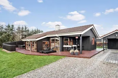 a house with a large deck in the yard at BL1144-Blokhus-Sixtusvej-27 in Blokhus