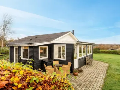 a black tiny house with a patio at Holiday Home Hjalma - 250m to the fjord by Interhome in Farsø