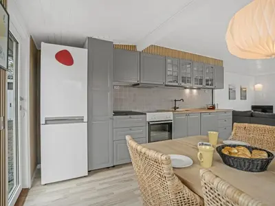 a kitchen with a table and a white refrigerator at Holiday Home Hjalma - 250m to the fjord by Interhome in Farsø