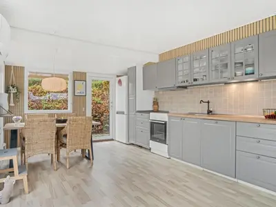 a kitchen with white cabinets and a table and chairs at Holiday Home Hjalma - 250m to the fjord by Interhome in Farsø