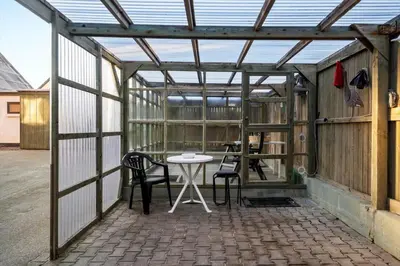 a glass greenhouse with a table and chairs in it at 729-Thyboron-Vesterhavsgade-112 in Thyborøn