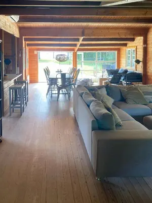 a living room with a large couch and a table at Log Cabin With Hot Tub And Fjord View in Viborg