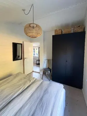 a bedroom with a bed and a black cabinet at Log Cabin With Hot Tub And Fjord View in Viborg