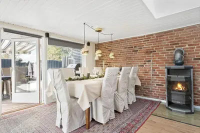 a dining room with a table and a fireplace at JB301-Fjerritslev-Landstien-3 in Fjerritslev