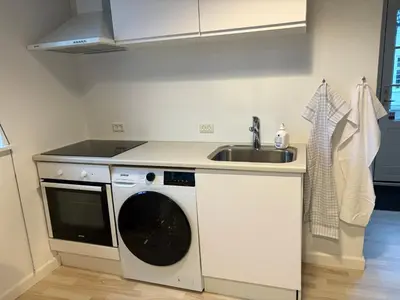 a kitchen with a sink and a washing machine at Kildebakkegaard Bed and Breakfast in Nørager