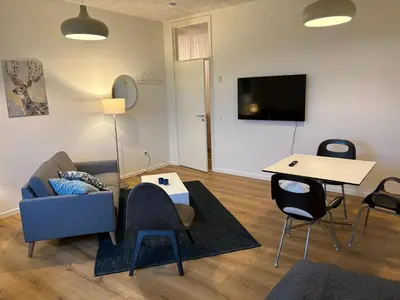 a living room with a couch and a table at Kildebakkegaard Bed and Breakfast in Nørager
