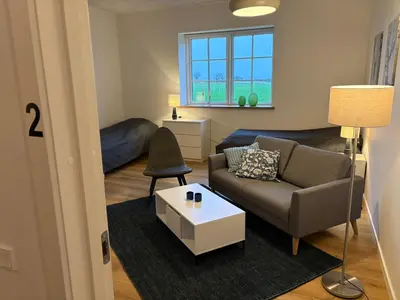 a living room with a couch and a table at Kildebakkegaard Bed and Breakfast in Nørager