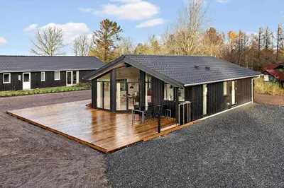 a house with a wooden deck in front of it at LF16138-Logstor-Marionsvej-38 in Trend