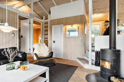 a living room with a fireplace in a tiny house at BL1141-Saltum-Faarup-Klitvej-2-A in Saltum
