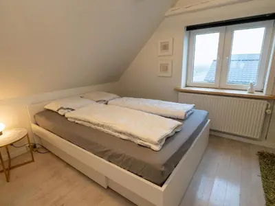 a bed in a room with a large window at 4 person holiday home in Hanstholm in Hanstholm