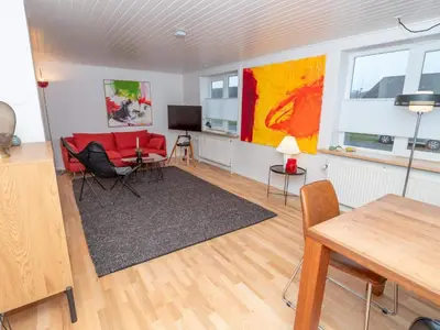 a living room with a red couch and a table at 4 person holiday home in Hanstholm in Hanstholm