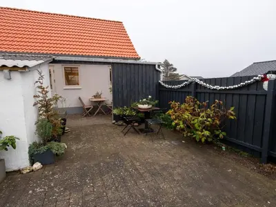 a backyard with a fence and a table and chairs at 4 person holiday home in Hanstholm in Hanstholm