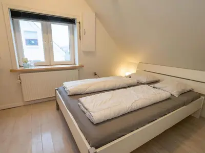 a bedroom with a bed with white sheets and a window at 4 person holiday home in Hanstholm in Hanstholm