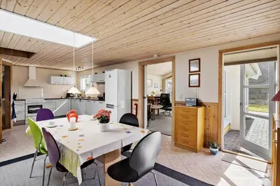 a kitchen and dining room with a table and chairs at JB404-Fjerritslev-Jesper-Jensensvej-9 in Slettestrand