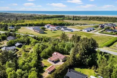 an aerial view of a house with trees and the ocean at JB404-Fjerritslev-Jesper-Jensensvej-9 in Slettestrand