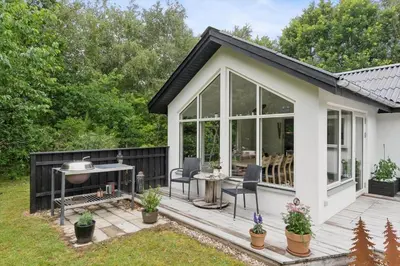 a cottage with a deck with chairs and a grill at LF18116-Veslos-Agerovej-6 in Amtoft