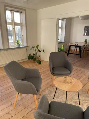 a living room with two chairs and a table at Lejlighed midt i Thisted in Thisted