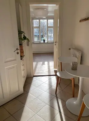 a kitchen with a table and a table and a door at Lejlighed midt i Thisted in Thisted