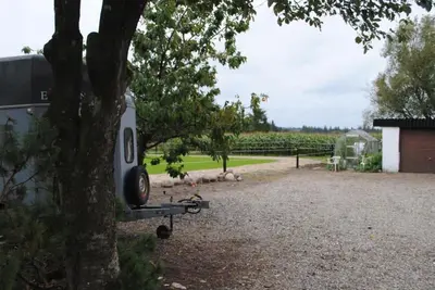 a trailer is parked next to a tree at Idyllic Countryside Farm with Horseback Riding in Nibe