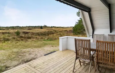 a porch with two chairs and a table on it at 2 Bedroom Pet Friendly Home In Thisted in Thisted